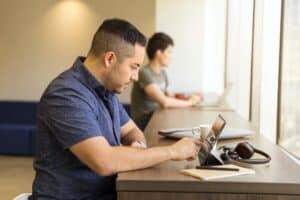 A guy with a lady beside him studying online